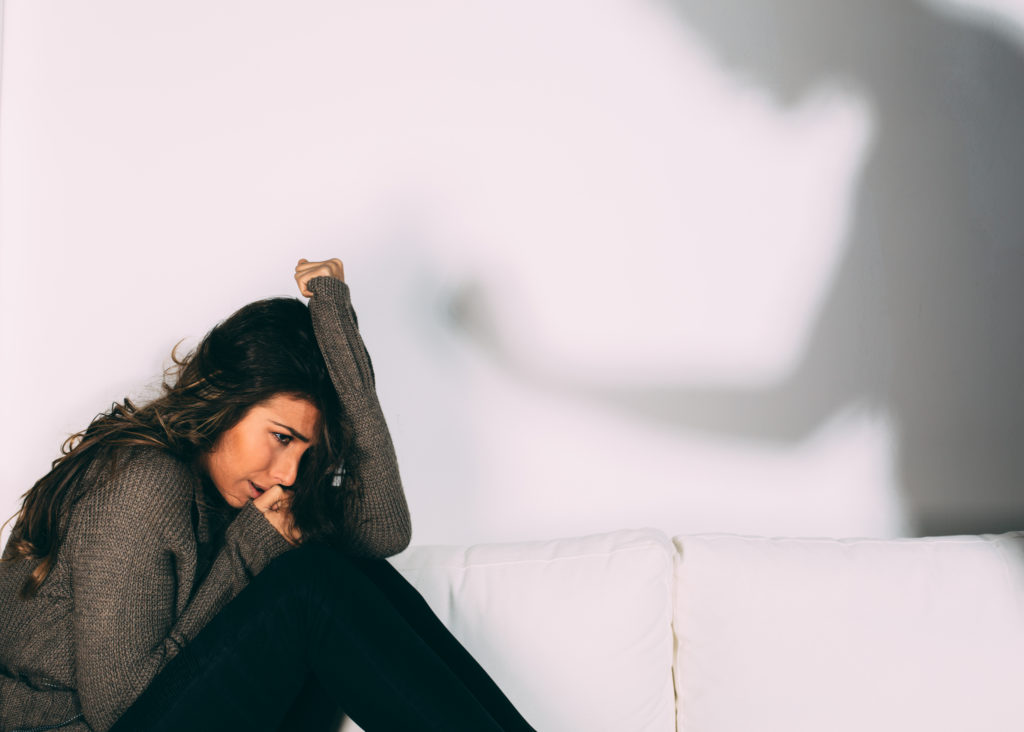 Women crying on a couch after experiencing domestic violence / abuse